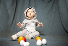 Little baby in hare jumpsuit and easter eggs stock images Little baby in hare jumpsuit and easter eggs stock images