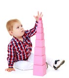 Little boy builds a pyramid in the Montessori