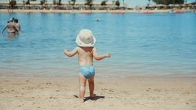 Little boy enjoying warm water at seaside. Cute child running at sand beach.