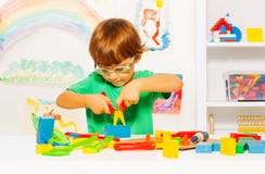 Little boy in glasses learning to use pliers stock photo Little boy in glasses learning to use pliers stock photo