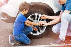 Little boy and his father changing wheels on a car Royalty Free Stock Images Little boy and his father changing wheels on a car Royalty Free Stock Images