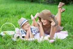 Little boy and teen age girl having picnic outdoors stock image Little boy and teen age girl having picnic outdoors stock image