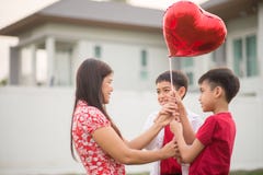 Little boys giving balloon heart to his mother love royalty free stock photo Little boys giving balloon heart to his mother love royalty free stock photo