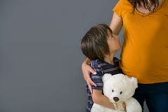 Little child, boy, hugging his pregnant mother at home, isolated royalty free stock image Little child, boy, hugging his pregnant mother at home, isolated royalty free stock image