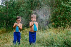 Little children splash water from the sprayer outdoors in summer stock photo Little children splash water from the sprayer outdoors in summer stock photo
