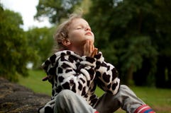Little curly girl prays sitting on a stone fence. Rest in the village. Prayer to God. Summer holidays royalty free stock photos Little curly girl prays sitting on a stone fence. Rest in the village. Prayer to God. Summer holidays royalty free stock photos