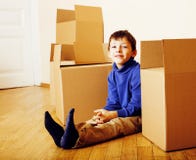 Little Cute Boy In Empty Room, Remoove To New House. Home Alone Emong Boxes Close Up Kid Smiling Stock Photography