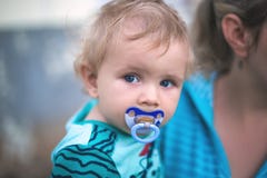 Little Cute Boy With A Baby Pacifier In His Mouth In His Mother` Royalty Free Stock Photos