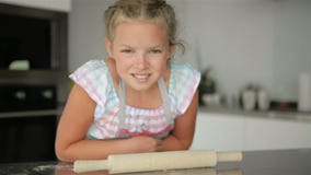 Little Cute Girl Is Cooking On Kitchen. Having Fun While Making Cakes and Cookies. Smiling And Looking At Camera. stock video footage Little Cute Girl Is Cooking On Kitchen. Having Fun While Making Cakes and Cookies. Smiling And Looking At Camera. stock video footage