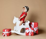 Little smiling baby sitting on a white horse, wooden rocking stock photography Little smiling baby sitting on a white horse, wooden rocking stock photography