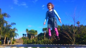 Little girl age 05 Jumping on a trampoline stock video footage Little girl age 05 Jumping on a trampoline stock video footage