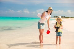 Little girl with camera and young mother walking at beach stock photos Little girl with camera and young mother walking at beach stock photos