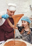 Cute girl with a chef creates chocolate, a home cooking hobby.