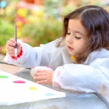 Little Girl Drawing On Stone Outdoors In Summer Sunny Day. royalty free stock photo Little Girl Drawing On Stone Outdoors In Summer Sunny Day. royalty free stock photo