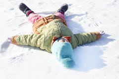 . little girl draws on the snow angel. shallow depth of field stock photo . little girl draws on the snow angel. shallow depth of field stock photo