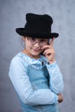 Little Girl In Glasses And Black Hat Stock Photography
