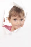 Little girl looks through a white wall stock photos Little girl looks through a white wall stock photos