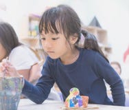 Little girl painting in art classroom stock photos Little girl painting in art classroom stock photos