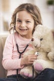 Little Girl playing Doctor with Teddy Bear stock photo Little Girl playing Doctor with Teddy Bear stock photo