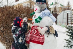 Little girl playing with snowman royalty free stock images Little girl playing with snowman royalty free stock images