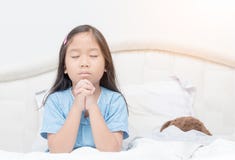 Little girl praying on bed, spirituality and religion. Royalty Free Stock Photo Little girl praying on bed, spirituality and religion. Royalty Free Stock Photo