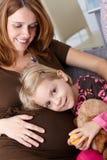 Little girl and pregnant mother smiling stock photo Little girl and pregnant mother smiling stock photo