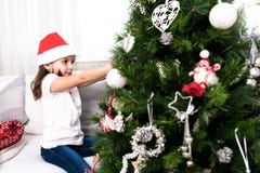 Little girl putting christmass tree ornaments stock photo Little girl putting christmass tree ornaments stock photo