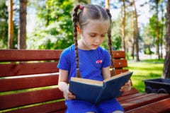 Little girl reading a book in the outdoors. stock images Little girl reading a book in the outdoors. stock images