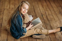 Little girl with teddy bear holding book, education kids concept stock images Little girl with teddy bear holding book, education kids concept stock images
