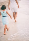 The little girl is trying to walk in the footsteps of her mother. stock photos The little girl is trying to walk in the footsteps of her mother. stock photos