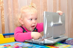 Little Girl With Child S Computer (notebook). Royalty Free Stock Images