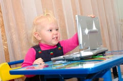 Little Girl With Child S Computer (notebook). Royalty Free Stock Photography