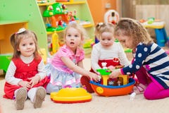 Little girls playing with toys in playroom