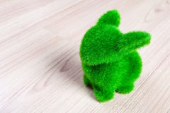 Little green rabbit on wooden floor, made from artificial grass Stock Photo Little green rabbit on wooden floor, made from artificial grass Stock Photo