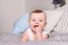 Little happy baby in white lies on bed with pillows royalty free stock image Little happy baby in white lies on bed with pillows royalty free stock image