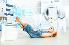 Little helper tired child girl to wash clothes and rest in laund Stock Photography Little helper tired child girl to wash clothes and rest in laund Stock Photography