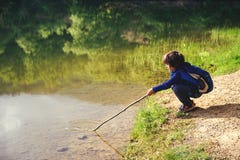 Child play fishing near lake. stock photo Child play fishing near lake. stock photo