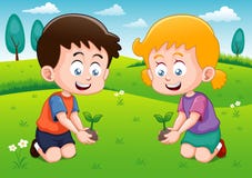 Little kids is planting small plant in garden