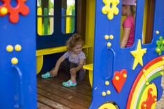 Little red-haired girl in a wooden house for children on the playground royalty free stock images Little red-haired girl in a wooden house for children on the playground royalty free stock images