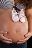 Little Shoes On A Pregnant Belly Royalty Free Stock Images