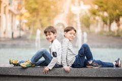 Little sibling boy sitting together at fountain outdoor stock images Little sibling boy sitting together at fountain outdoor stock images