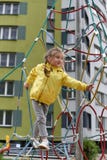 A little smiling girl using the sports equipment in a playground of an apartment house`s court yard royalty free stock photos A little smiling girl using the sports equipment in a playground of an apartment house`s court yard royalty free stock photos