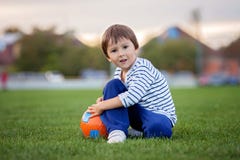 Little toddler boy playing soccer and football, having fun outdo Stock Photo Little toddler boy playing soccer and football, having fun outdo Stock Photo