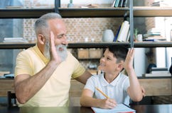Livello di prima generazione allegro e del nipote che fiving a casa fotografia stock Livello di prima generazione allegro e del nipote che fiving a casa fotografia stock
