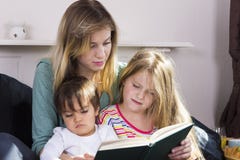 Livre de lecture fatigué de mère aux enfants Photo libre de droits Livre de lecture fatigué de mère aux enfants Photo libre de droits