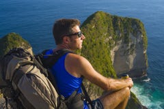 Livsstildet friastående av den unga attraktiva och stiliga mannen med den trekking strandklippan för ryggsäck som ser det här royaltyfri bild Livsstildet friastående av den unga attraktiva och stiliga mannen med den trekking strandklippan för ryggsäck som ser det här royaltyfri bild