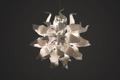 Ljuskrona hängelampa, vit glass lampa i form av blommakronblad vit original- lampa på en grå bakgrund arkivbilder Ljuskrona hängelampa, vit glass lampa i form av blommakronblad vit original- lampa på en grå bakgrund arkivbilder