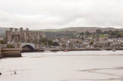 LLandudno, Gales, Reino Unido - 27 de maio de 2018 rio que flui ao lado do castelo Barcos que flutuam no rio Ponte sobre o rio Ca fotografia de stock royalty free LLandudno, Gales, Reino Unido - 27 de maio de 2018 rio que flui ao lado do castelo Barcos que flutuam no rio Ponte sobre o rio Ca fotografia de stock royalty free