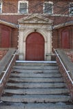 Lle scala incrinate conducono ad una porta rossa fotografia stock Lle scala incrinate conducono ad una porta rossa fotografia stock