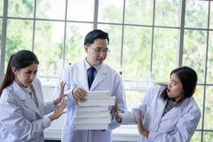 Lo scienziato asiatico senior ha assegnazione del lavoro nuovo agli studenti in laboratorio immagine stock libera da diritti Lo scienziato asiatico senior ha assegnazione del lavoro nuovo agli studenti in laboratorio immagine stock libera da diritti